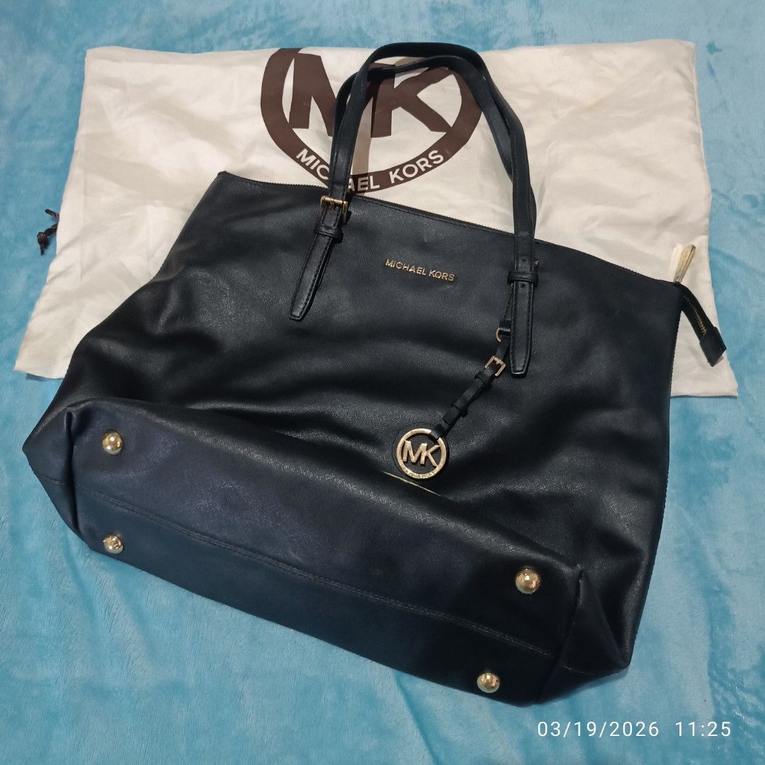 Michael Kors Black Tote Bag (Category: Tote Bags) located in Bacoor. Submitted by pamelott (Listing ID 1427335150, Image 2). Description: This is a Michael Kors Jet Set Travel Tote, a classic and versatile handbag designed for everyday use or travel. ​Design & Features ​Material: Made from Saffiano leather ​Color: Classic Black with Gold-tone hardware. ​Logo Details: * Features the "MICHAEL KORS" block lettering in metal on the front. ​Includes a