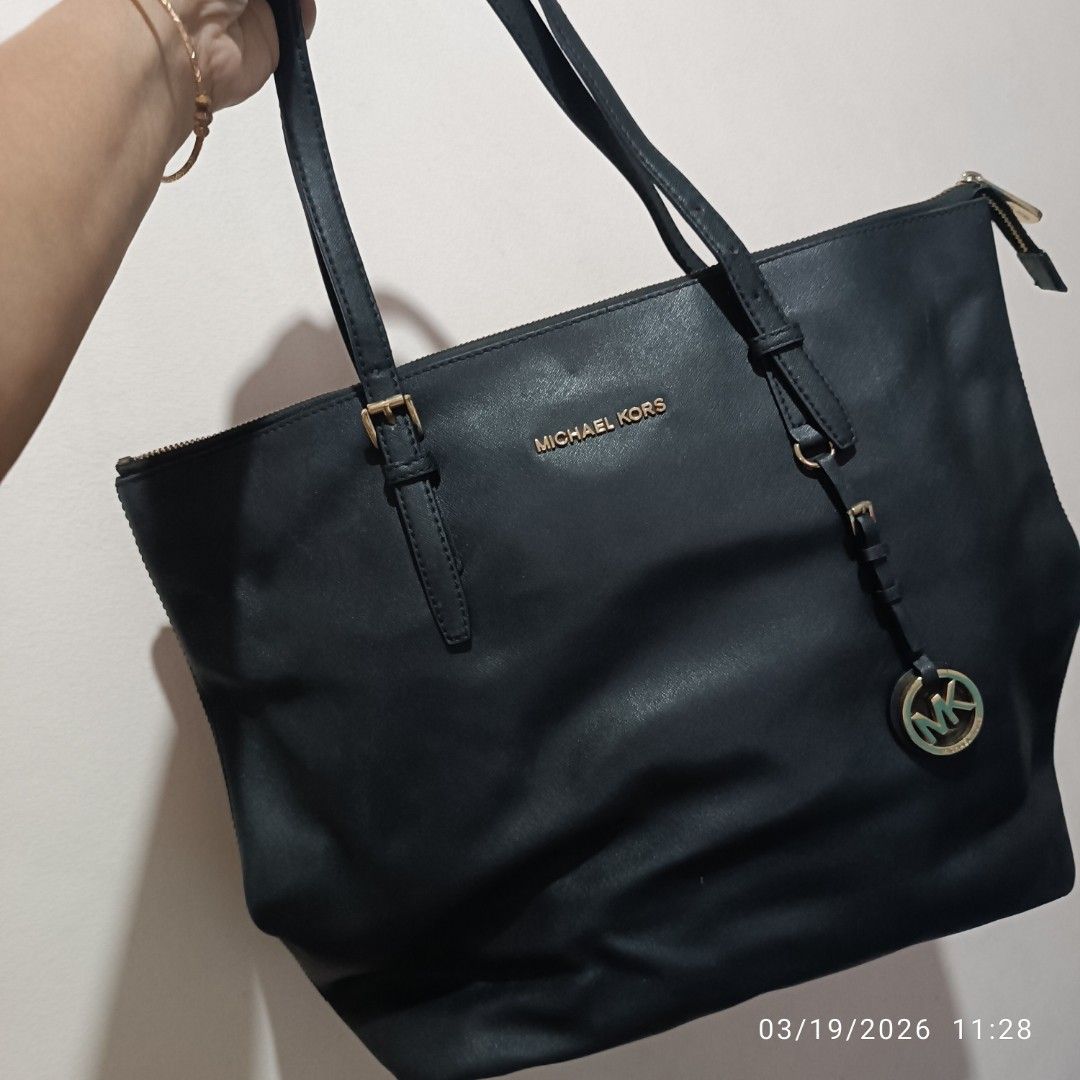 Michael Kors Black Tote Bag (Category: Tote Bags) located in Bacoor. Submitted by pamelott (Listing ID 1427335150, Image 3). Description: This is a Michael Kors Jet Set Travel Tote, a classic and versatile handbag designed for everyday use or travel. ​Design & Features ​Material: Made from Saffiano leather ​Color: Classic Black with Gold-tone hardware. ​Logo Details: * Features the "MICHAEL KORS" block lettering in metal on the front. ​Includes a