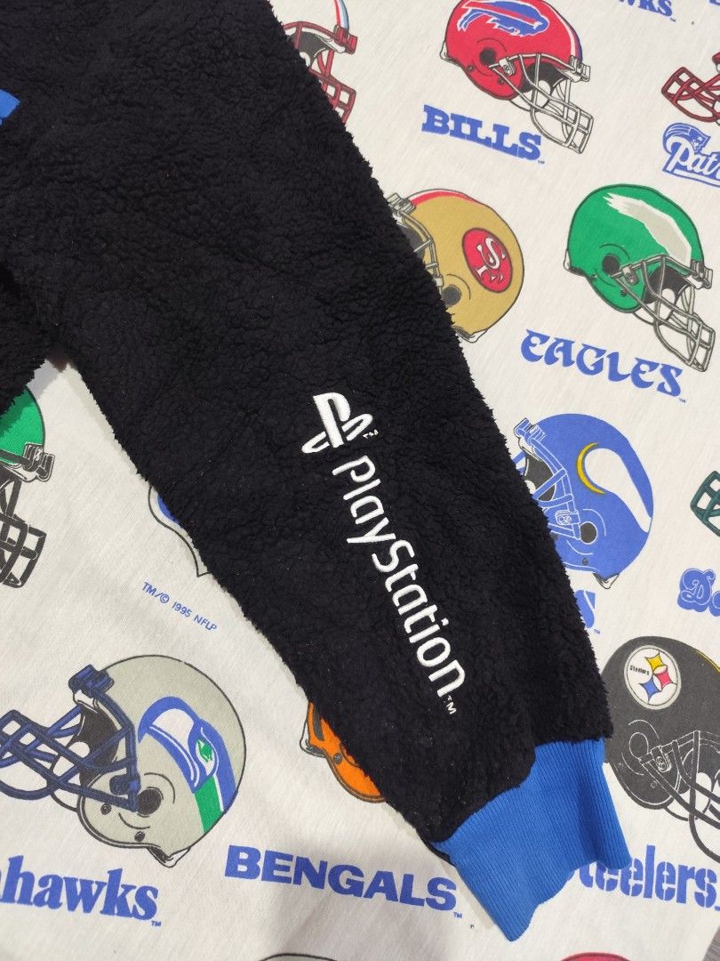 PlayStation Black Sweatshirt XL (Category: Coats, Jackets and Outerwear) located in Baguio. Submitted by FRANKLIN (Listing ID 1427379892, Image 3). Description: Black sweatshirt with blue accents. Features a PlayStation logo pocket and PlayStation text on the sleeve. The size is XL. The sweatshirt has a blue collar and cuffs. The back of the sweatshirt is plain black. The tag indicates the material composition..