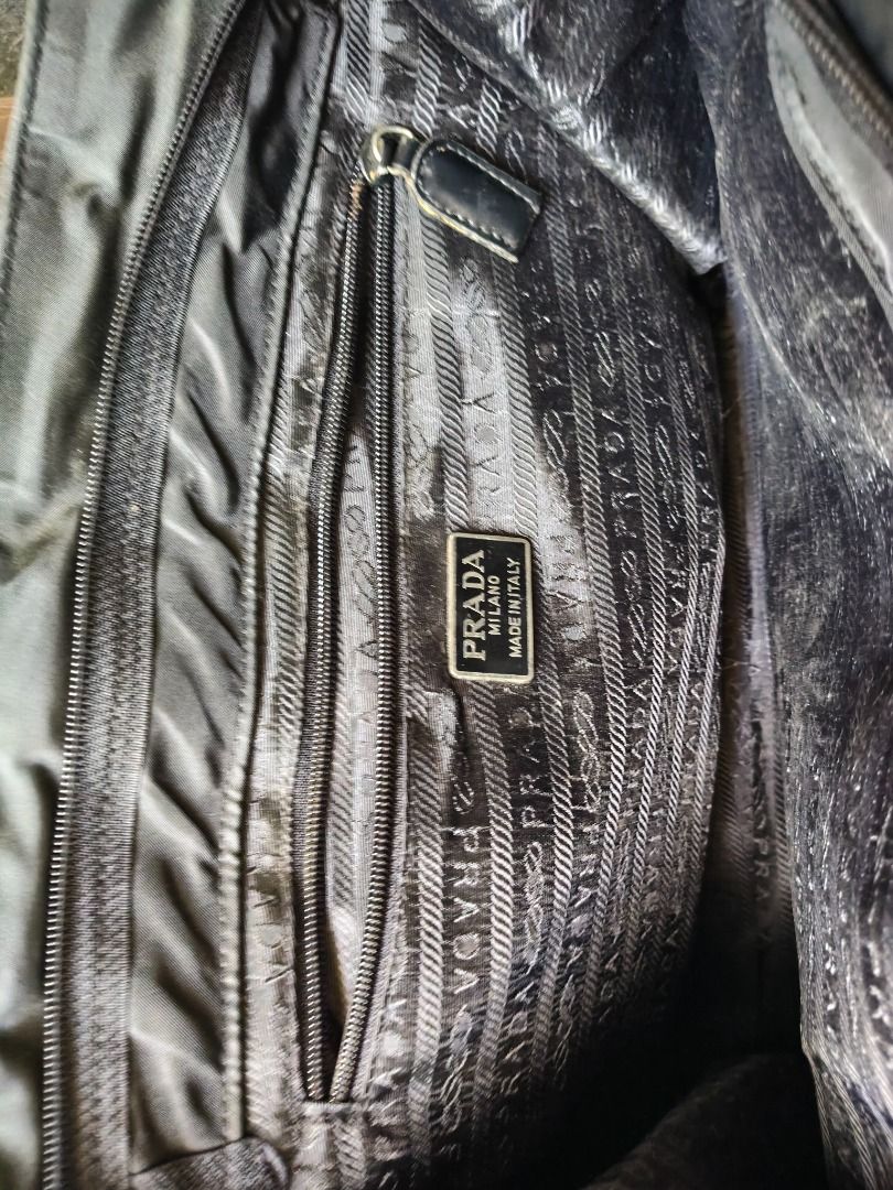 Prada Black Nylon Tote Bag (Category: Luxury Bags & Wallets) located in Caloocan City. Submitted by balizaclar77072 (Listing ID 1427453350, Image 3). Description: Black Prada tote bag. Features a top handle design with a zipper closure on the back. The interior includes a small pocket with a Prada label. The bag has a triangular Prada logo on the front. Made in Italy..
