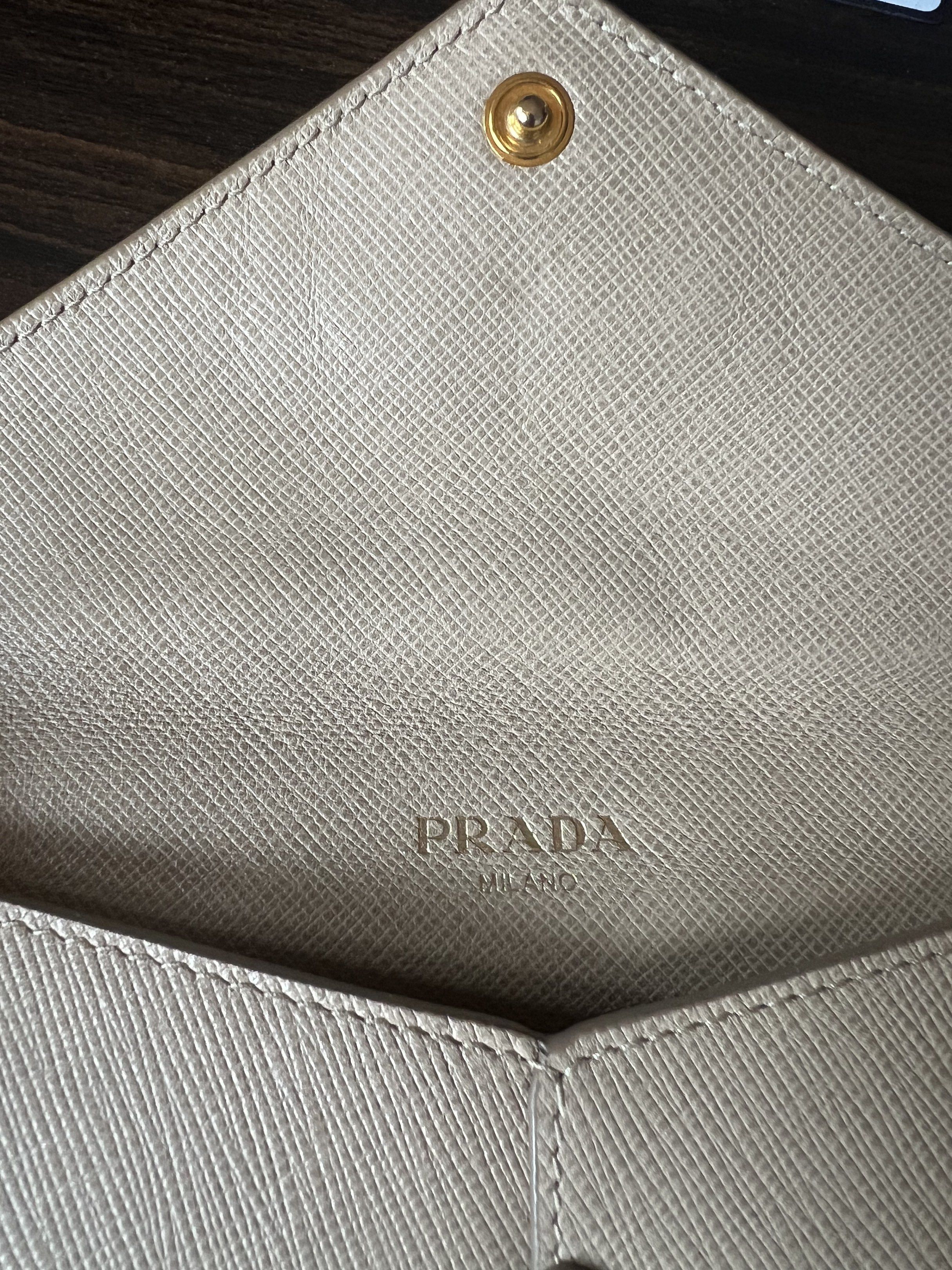 Prada Saffiano Envelope Wallet (Category: Luxury Bags & Wallets) located in Muntinlupa City. Submitted by thecatwalk (Listing ID 1427323924, Image 3). Description: Authentic Prada Saffiano Leather Envelope wallet in Beige With Authenticity cards Pre-loved in great condition No flaws 3 card inner pockets 1 outside zipper pocket Perfect for traveling, can fit passport, cash cards and coins. Super chic, sleek design .