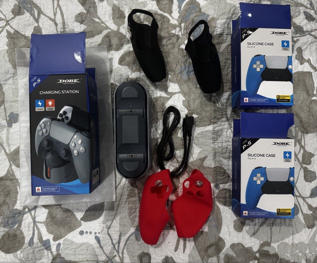 PS5 DualSense charging dock and silicone case (Category: PlayStation) located in Paranaque City. Submitted by gelato09 (Listing ID 1427446744, Image 1). Description: PS5 DualSense charging dock and silicone case Price: 300 FIXED Dobe charging dock for DualSense - complete packaging, used once, good as new Dobe silicone case for DualSense (2 pcs) - complete packaging, used once, good as new Pick up only at BF Homes Parañaque City. Buyer books and 