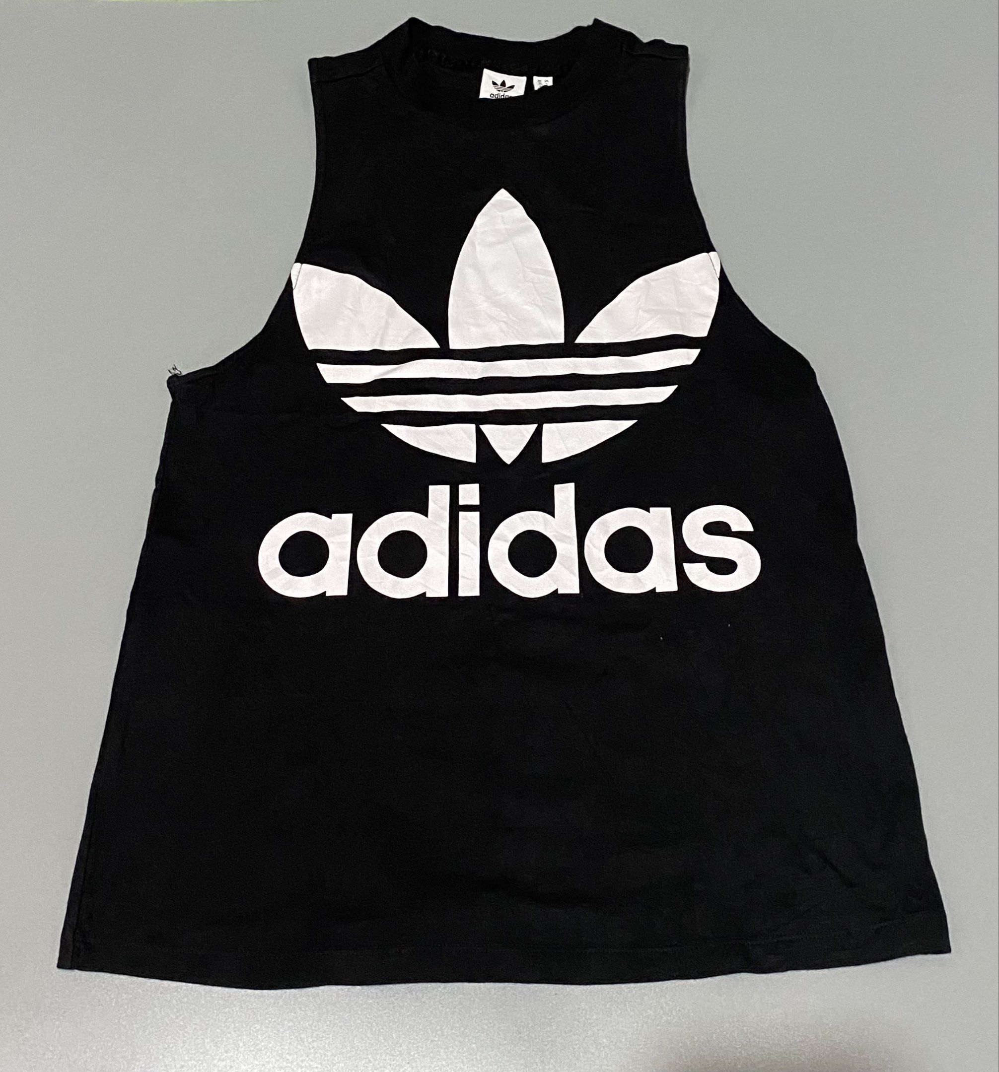 Adidas Trefoil Tank Top - Black (Category: Sleeveless) located in Tagum. Submitted by thriftedjon (Listing ID 1424297645, Image 1). Description: - Authentic Adidas tank top - Color: Black - Features a large white Trefoil logo and Adidas text on the front - Sleeveless design - Size: S/P - Made in Pakistan - Small Adidas logo on the back of the neck.