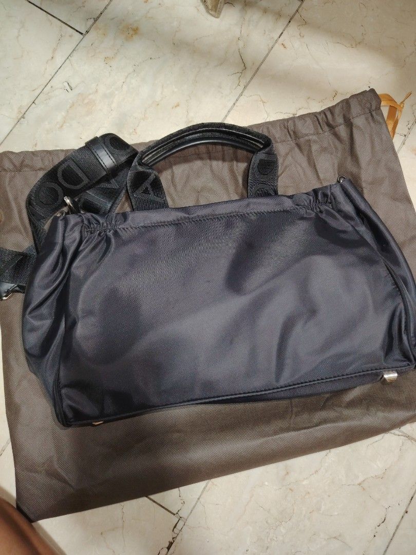 Adolfo Dominguez Black Handbag with Shoulder Strap (Category: Shoulder Bags) located in Cainta. Submitted by badet0521 (Listing ID 1424222368, Image 2). Description: - Adolfo Dominguez black handbag - Top handle and detachable shoulder strap - Includes dust bag - Zippered main compartment - Multiple interior pockets - Gold-toned hardware - Smooth exterior material (possibly nylon).