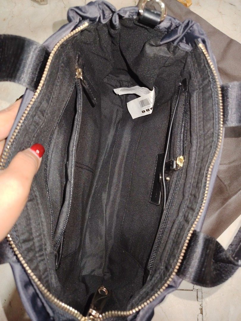 Adolfo Dominguez Black Handbag with Shoulder Strap (Category: Shoulder Bags) located in Cainta. Submitted by badet0521 (Listing ID 1424222368, Image 3). Description: - Adolfo Dominguez black handbag - Top handle and detachable shoulder strap - Includes dust bag - Zippered main compartment - Multiple interior pockets - Gold-toned hardware - Smooth exterior material (possibly nylon).
