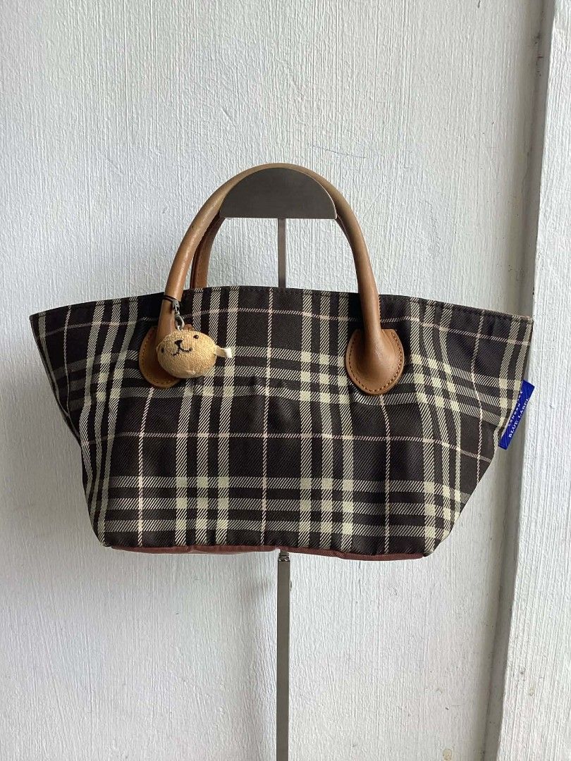 Burberry Blue Label Handbag (Category: Luxury Bags & Wallets) located in Cavite. Submitted by benta_bounce (Listing ID 1424234559, Image 1). Description: - Authentic Burberry Blue Label handbag - Measurements: Width 32 cm x Height 15 cm x Depth 15 cm - Classic check pattern (brown and beige) - Includes adorable bear charm - Features leather handles - Secure zip closure - Interior lined with pink fabric - Includes brand tag - Made in Japan.