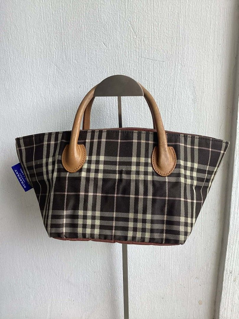 Burberry Blue Label Handbag (Category: Luxury Bags & Wallets) located in Cavite. Submitted by benta_bounce (Listing ID 1424234559, Image 2). Description: - Authentic Burberry Blue Label handbag - Measurements: Width 32 cm x Height 15 cm x Depth 15 cm - Classic check pattern (brown and beige) - Includes adorable bear charm - Features leather handles - Secure zip closure - Interior lined with pink fabric - Includes brand tag - Made in Japan.
