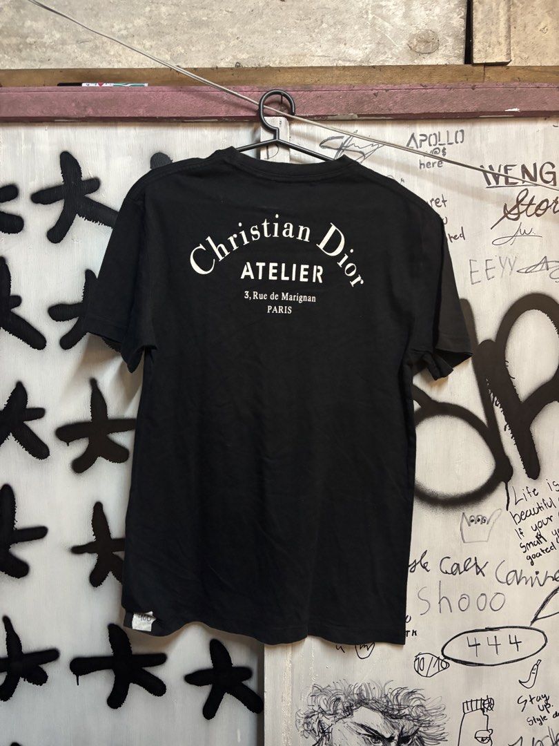 Christian Dior Atelier Black T-shirt (Category: Tshirts & Polo Shirts ) located in Quezon City. Submitted by tarphouse (Listing ID 1424324924, Image 2). Description: - Authentic Christian Dior Atelier T-shirt - Features the Christian Dior Atelier logo on the front - Back of shirt displays '3, Rue de Marignan PARIS' - Classic crew neck design - Short sleeves - Includes Christian Dior Paris tag.