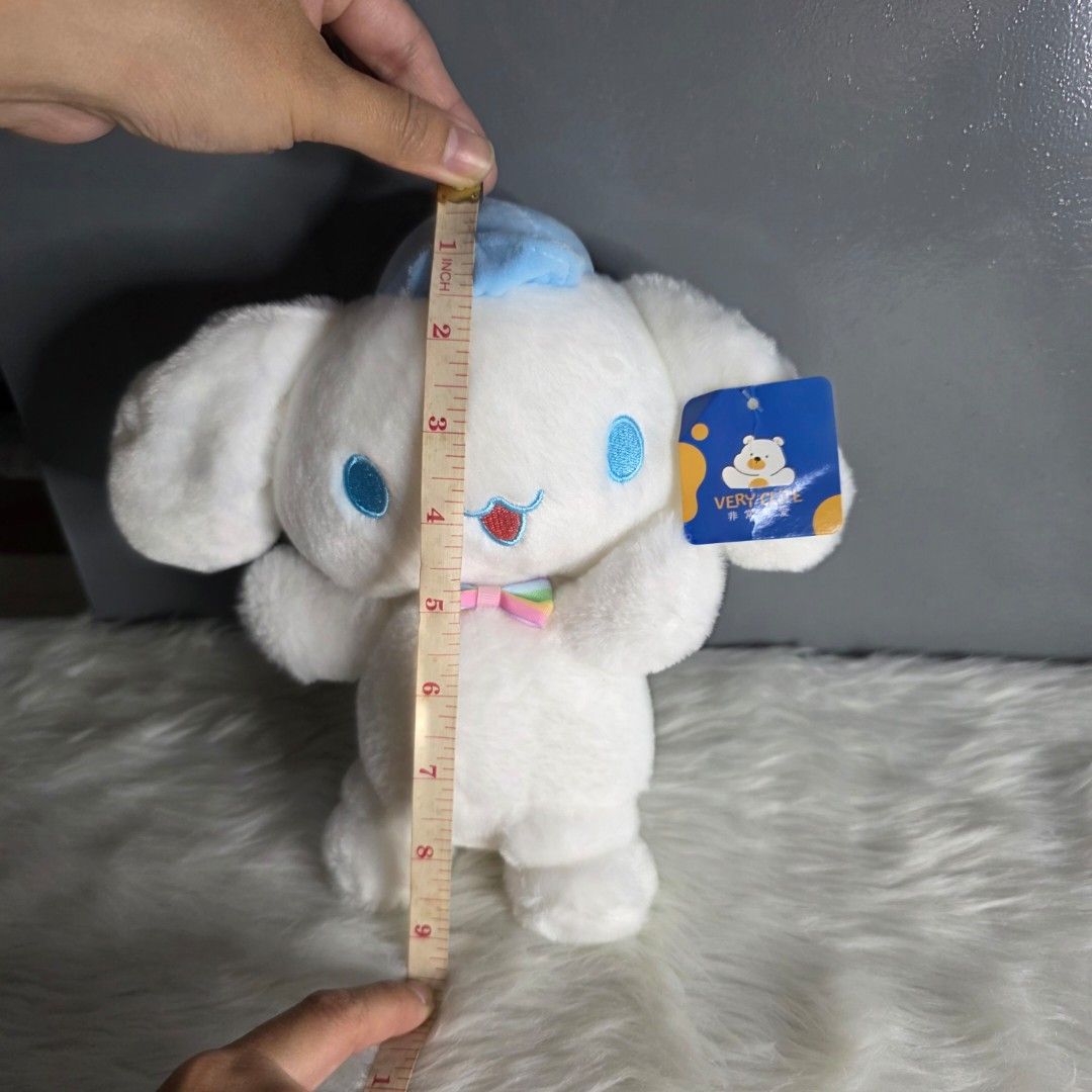 Cinnamoroll Plush Toy Claw Machine (Category: Plushies & Soft Toys) located in Valenzuela. Submitted by cbianx (Listing ID 1424179193, Image 3). Description: - Adorable Cinnamoroll plush toy - Features a blue hat and a rainbow bow - Soft and cuddly white plush - Includes tag - not official - Measures approximately 9 inches in length.