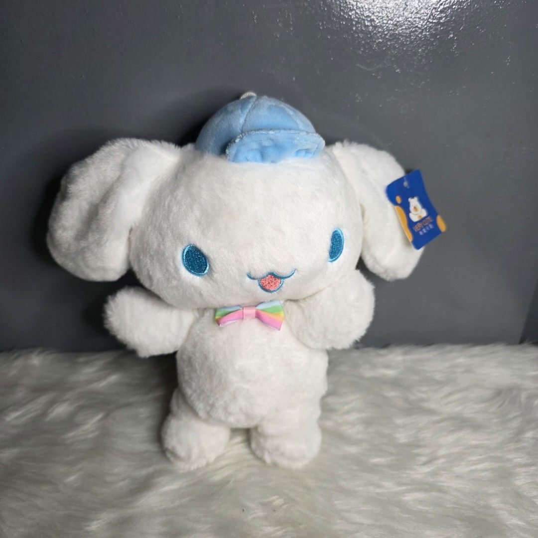 Cinnamoroll Plush Toy Claw Machine (Category: Plushies & Soft Toys) located in Valenzuela. Submitted by cbianx (Listing ID 1424179193, Image 1). Description: - Adorable Cinnamoroll plush toy - Features a blue hat and a rainbow bow - Soft and cuddly white plush - Includes tag - not official - Measures approximately 9 inches in length.