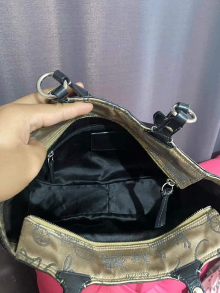 Coach Tote Bag with Carriage Print (Category: Luxury Bags & Wallets) located in Caloocan City. Submitted by cessang24 (Listing ID 1424323057, Image 3). Description: Coach tote bag featuring a classic carriage print. It has black leather handles and trim, with silver hardware accents. The bag has a beige background with a repeating pattern of carriages and the Coach logo..