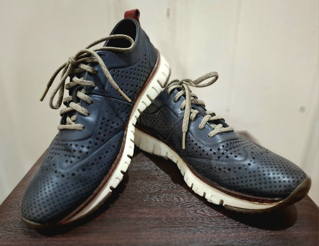 Cole Haan ZEROGRAND Perforated Leather Shoes (Category: Casual Shoes) located in Mandaluyong City. Submitted by redmgn (Listing ID 1424271121, Image 1). Description: - Cole Haan ZEROGRAND shoes - navy blue leather upper - White and brown soles - Lace-up closure - Red heel accent - "COLE HAAN" and "ZEROGRAND" sole markings.