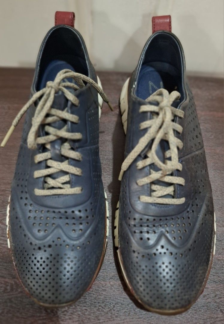 Cole Haan ZEROGRAND Perforated Leather Shoes (Category: Casual Shoes) located in Mandaluyong City. Submitted by redmgn (Listing ID 1424271121, Image 2). Description: - Cole Haan ZEROGRAND shoes - navy blue leather upper - White and brown soles - Lace-up closure - Red heel accent - "COLE HAAN" and "ZEROGRAND" sole markings.