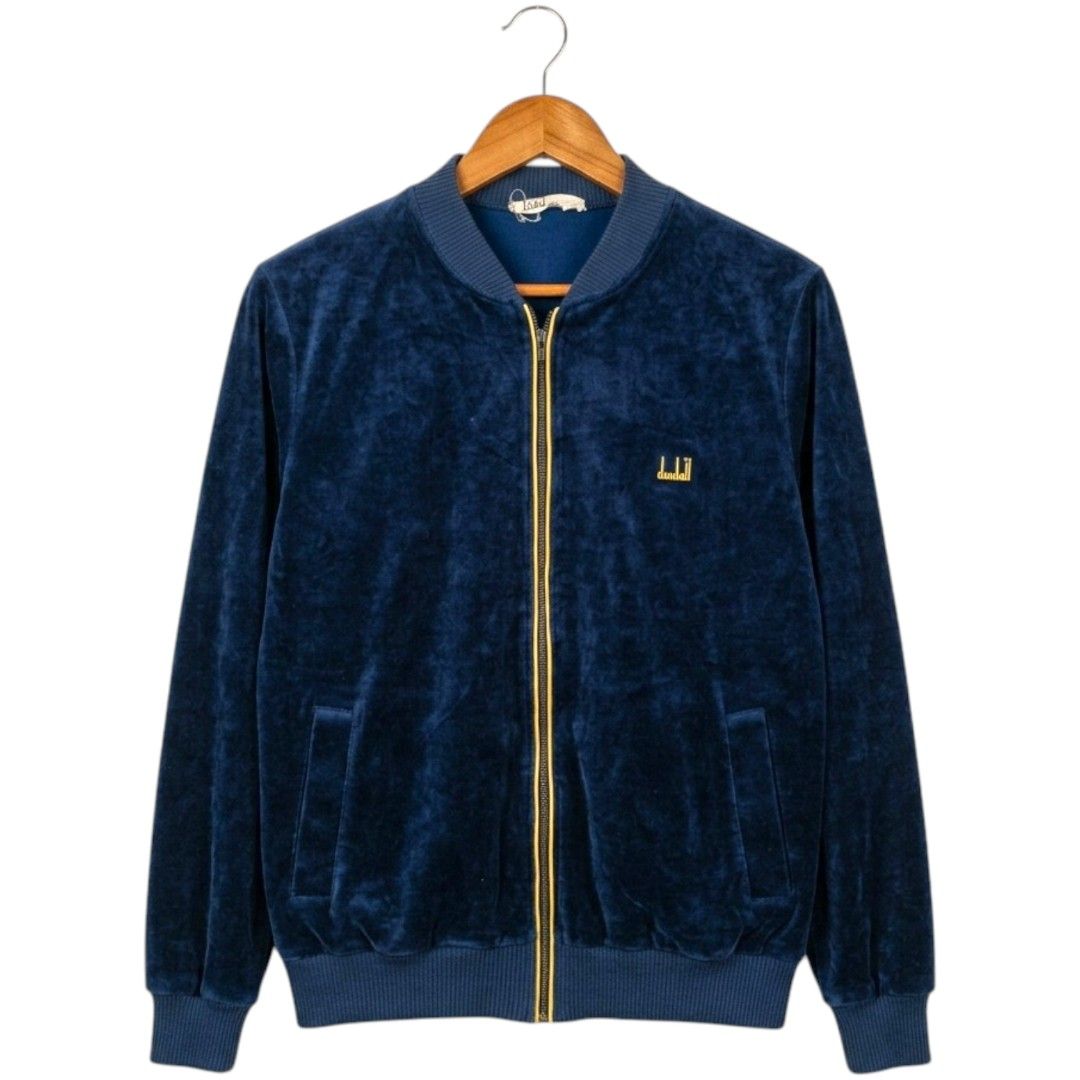Dunhill London Velvet Jacket (Category: Coats, Jackets and Outerwear) located in Baguio. Submitted by luxeloom099 (Listing ID 1424337510, Image 1). Description: Navy blue velvet jacket from Dunhill London. Features a gold zipper and the Dunhill logo embroidered on the chest. The label indicates it's made in Switzerland with a blend of cotton and polyamide. Ribbed collar and cuffs. A stylish and classic piece. 26l x 20w.