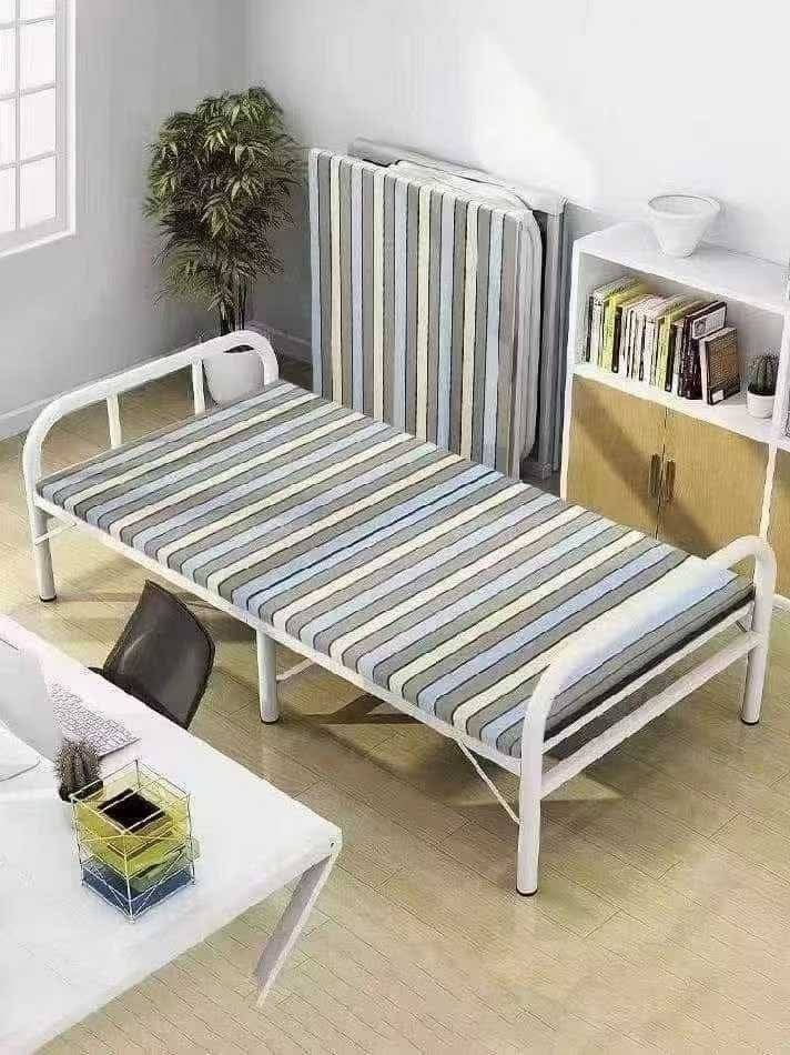Folding Bed with Mattress (Category: Bed Frames & Mattresses) located in Manila. Submitted by nixdcruz (Listing ID 1424293582, Image 1). Description: Folding bed comes with a mattress. It features a striped mattress design and a white metal frame. The bed folds up for easy storage. The bed is still in its original packaging..