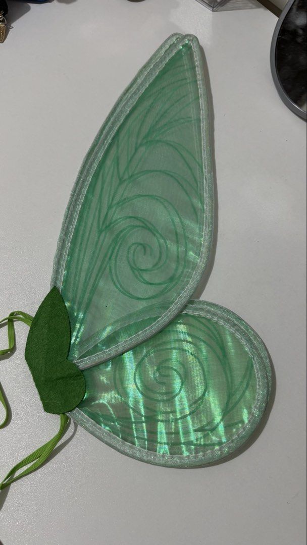 Iridescent Fairy Wings (Category: Other Accessories) located in Bauan. Submitted by berryhoon24 (Listing ID 1424314948, Image 3). Description: These fairy wings feature an iridescent design with a variety of colors. They have a green felt accent and elastic straps for easy wear. The wings are lightweight and suitable for costumes or dress-up. They are perfect for adding a touch of magic to any outfit. rfs: extra.