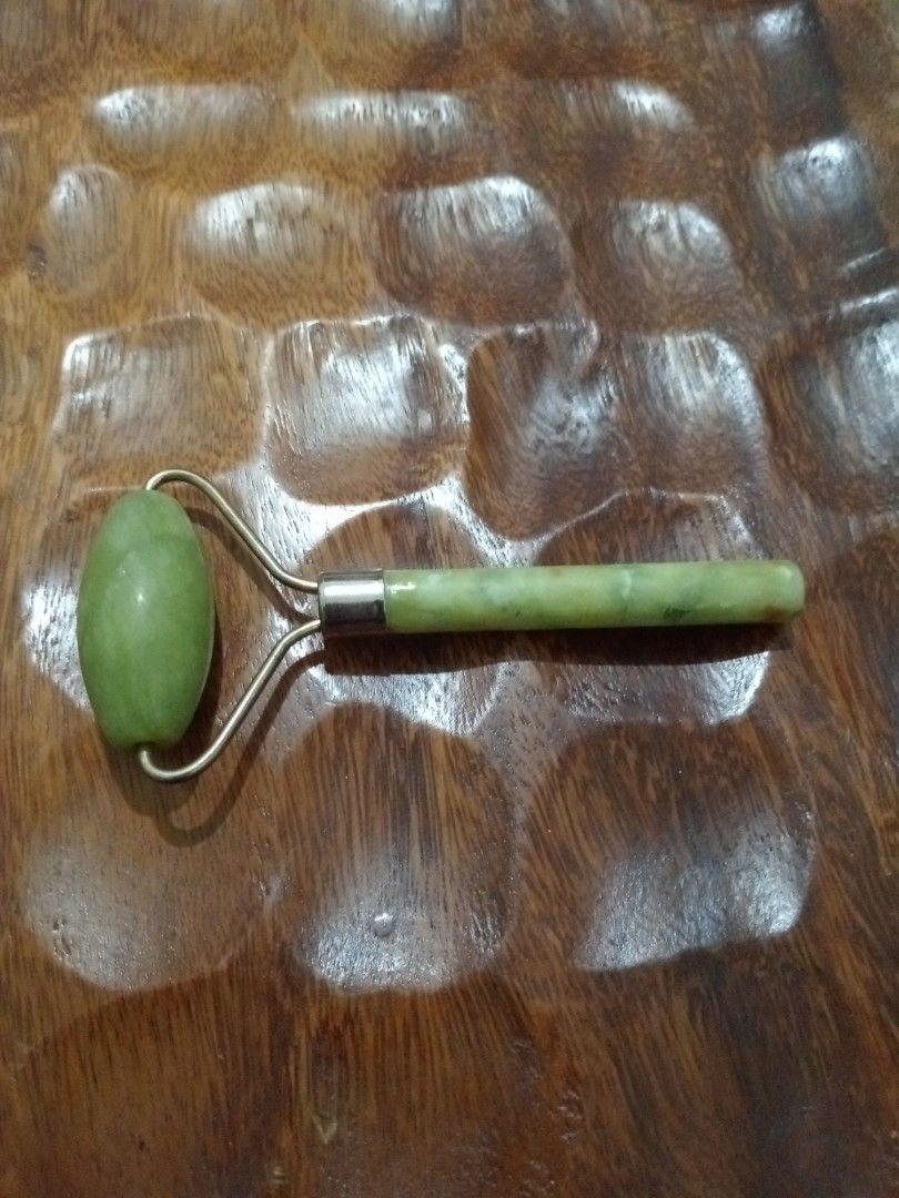 Jade Facial Roller (Category: Face Care) located in Batangas. Submitted by girlmeetspurple (Listing ID 1424178177, Image 3). Description: Uses: Used for facial massage to promote blood circulation, reduce puffiness, and improve skin elasticity. Features: Typically features a large stone for cheeks and forehead, and a smaller stone for delicate areas like the eyes. Benefits: Helps increase collagen production and enhance overall skin health. Usage