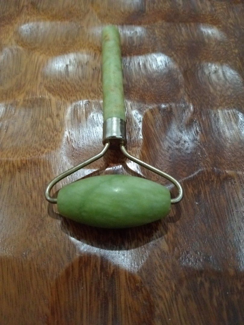 Jade Facial Roller (Category: Face Care) located in Batangas. Submitted by girlmeetspurple (Listing ID 1424178177, Image 2). Description: Uses: Used for facial massage to promote blood circulation, reduce puffiness, and improve skin elasticity. Features: Typically features a large stone for cheeks and forehead, and a smaller stone for delicate areas like the eyes. Benefits: Helps increase collagen production and enhance overall skin health. Usage
