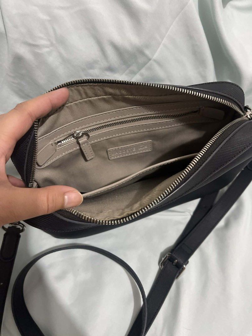 Lacoste Black Crossbody Bag (Category: Cross-body Bags) located in Cabanatuan. Submitted by krnlim (Listing ID 1420578831, Image 2). Description: - Black Lacoste crossbody bag - Rectangular shape - Silver Lacoste logo - Adjustable long strap - Silver hardware - Textured exterior - Ideal for daily use.