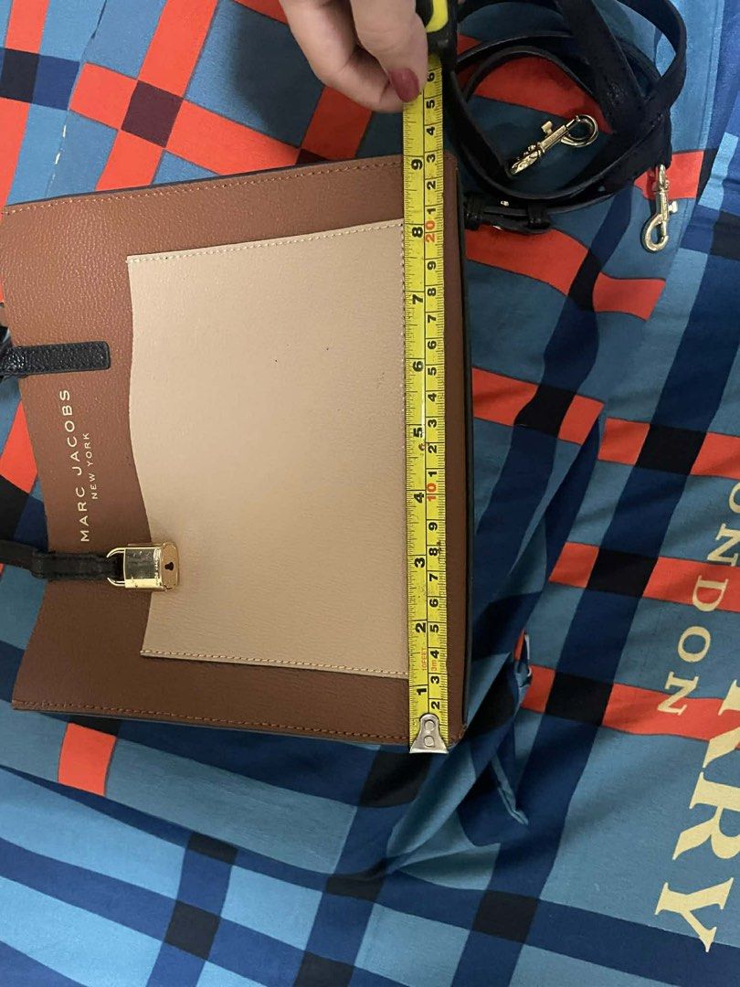 Marc Jacobs New York Handbag (Category: Luxury Bags & Wallets) located in Cavite. Submitted by sleigh21 (Listing ID 1424183572, Image 3). Description: - Marc Jacobs handbag - Color block design: brown, black, beige - Top handle - Zip closure - Gold-tone lock detail - Detachable strap - Approximately 8 inches in height - Great for everyday use.
