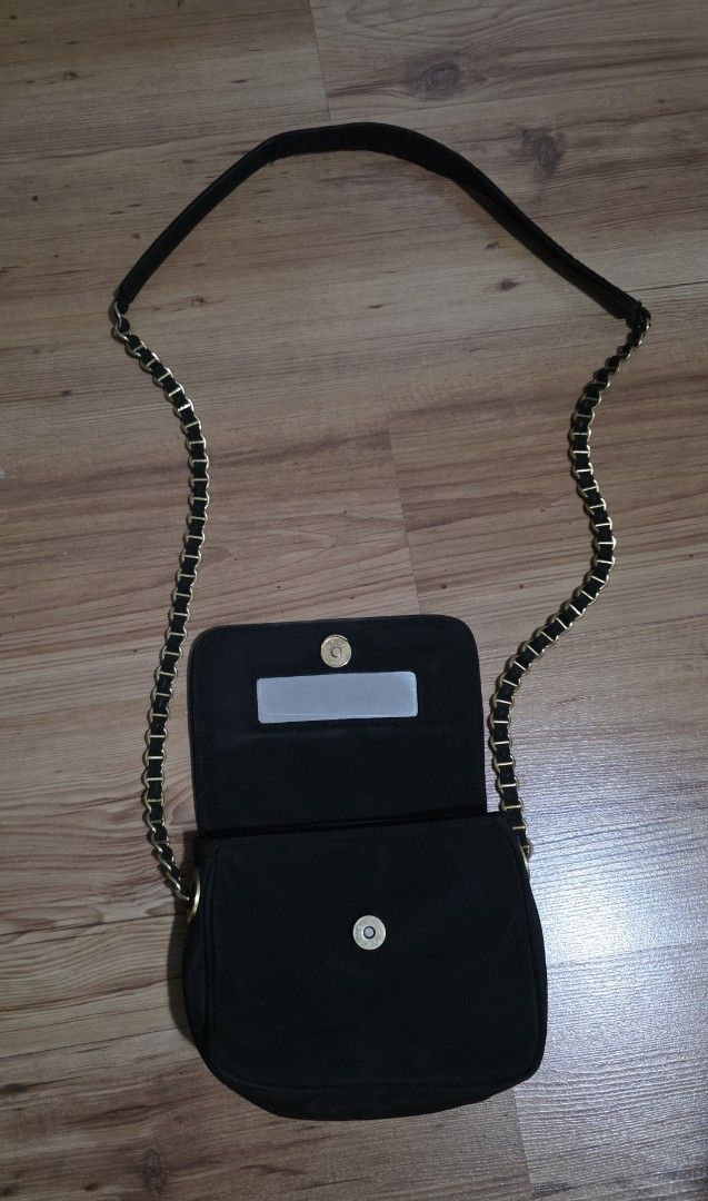 Nine West Black Sling Bag with Chain Strap (Category: Luxury Bags & Wallets) located in Manila. Submitted by tresmmm (Listing ID 1424299818, Image 3). Description: - Black sling bag - Chain strap - Flap closure with button - Interior mirror - Brand: Nine West - Silver rectangular tag on front.