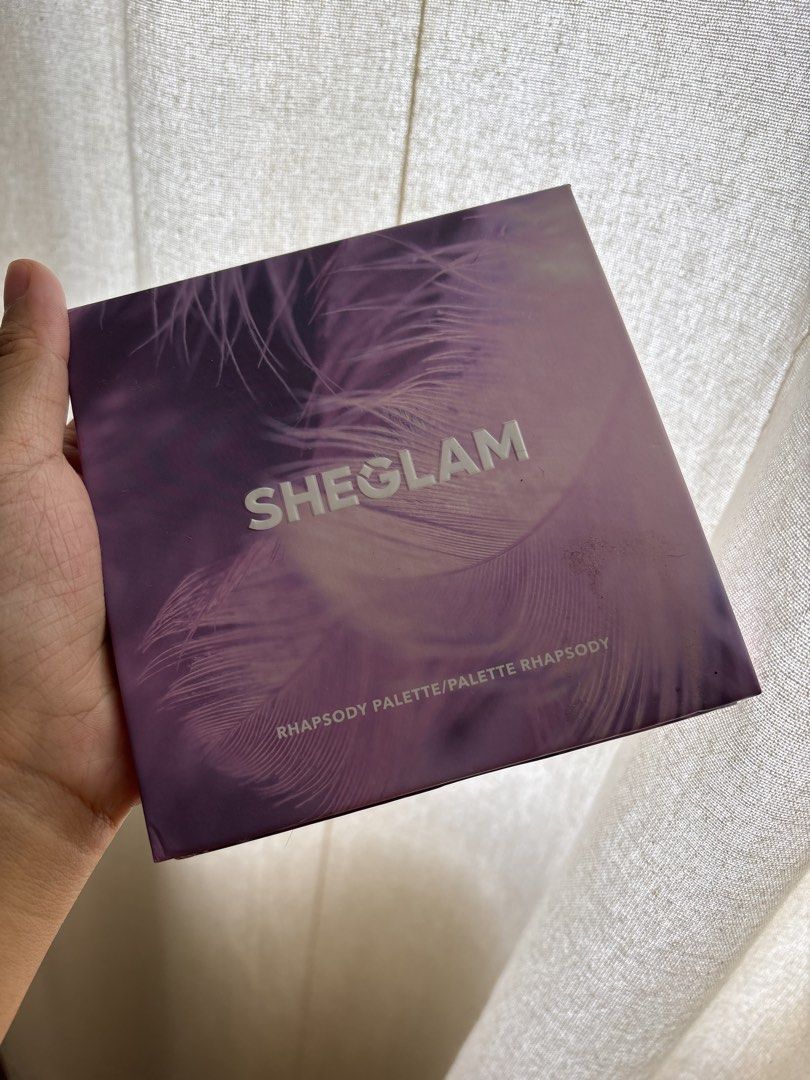 SHEGLAM Rhapsody Eyeshadow Palette (Category: Makeup) located in Imus. Submitted by _declutterby (Listing ID 1424186595, Image 3). Description: - SHEGLAM Rhapsody Palette - Nine eyeshadow shades - Includes shades like Unicorn, Petal, You, Tangerine, Lavender, Lily, Escape, Pink Me, and Mandala - Features purples, pinks, and neutral tones - Brand new, in original packaging.
