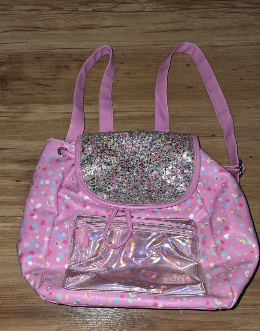 Smiggle Pink Glittery Drawstring Backpack (Category: Babies & Kids Fashion) located in Manila. Submitted by tresmmm (Listing ID 1424305675, Image 1). Description: smiggle backpack can be used as lunch bag.