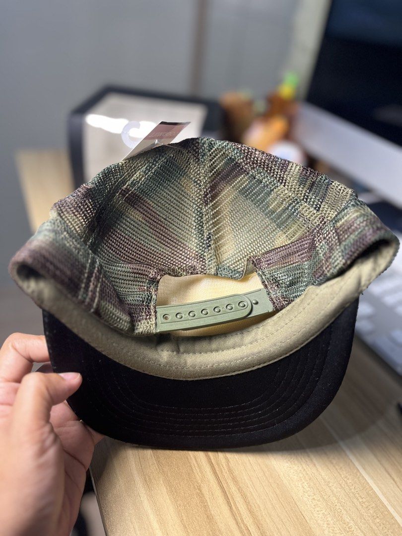 South Bay BBQ Trucker Cap (Category: Caps & Hats) located in Dasmarinas. Submitted by margo09 (Listing ID 1424310708, Image 2). Description: Trucker cap features a black brim and a tan front panel with the "South Bay BBQ" logo. The back is a camouflage mesh with an adjustable strap. The cap has a Dist. Vice tag attached..