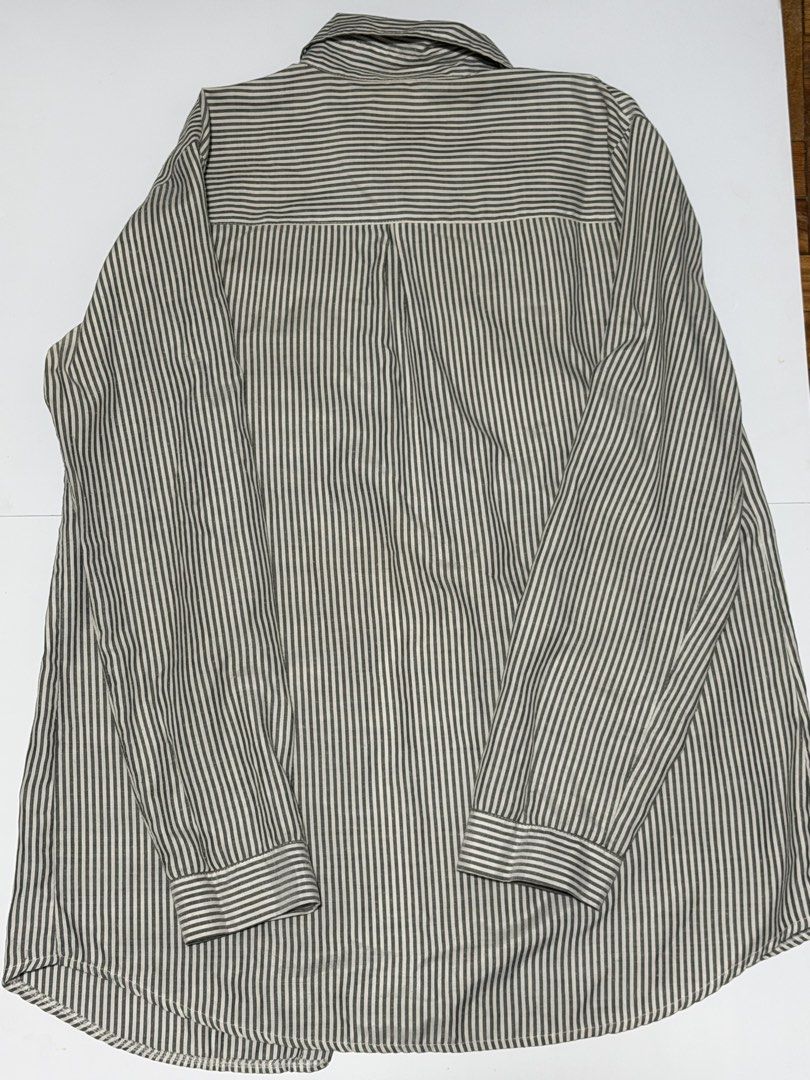 Striped Long Sleeve Shirt (Category: Tshirts & Polo Shirts ) located in Caloocan City. Submitted by _mitsuki (Listing ID 1424183252, Image 3). Description: ‼️ DECLUTTERING ‼️ Model Height: 5'6 Model Weight: 69.5kg Classic long-sleeved shirt with vertical stripes. Features a collared neckline and button-down closure. The sleeves have a buttoned cuff and a buttoned tab for rolling up. The shirt has a relaxed fit, suitable for casual wear. MOP: Unio