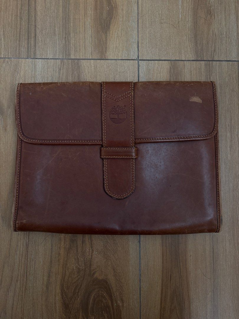 Timberland Leather Laptop / Document /Art Holder (Category: Laptop Bags & Sleeves) located in Imus. Submitted by _declutterby (Listing ID 1424202241, Image 1). Description: - Genuine Timberland leather laptop sleeve - Rare vintage. 1980s. - Brown exterior with flap closure - Features Timberland logo - Yellow lined interior - Includes zippered pocket and multiple compartments - Made in Italy - Snap closure - Well-constructed.