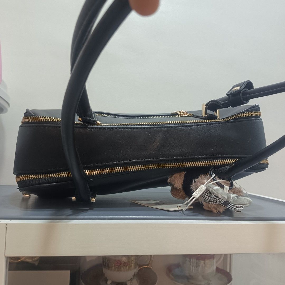 Vegan Confessions Black Handbag (Category: Luxury Bags & Wallets) located in Dagupan City. Submitted by nmcmp4 (Listing ID 1424237165, Image 3). Description: - Black handbag from Vegan Confessions - Rectangular shape - Double handles - Gold-colored zippers - Includes small bear plushie - Made of smooth, leather-like material - Simple and elegant design - No box - Suitable for everyday use.