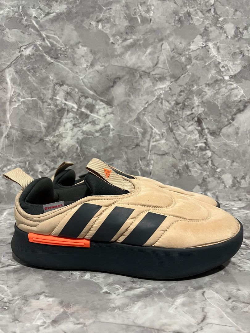 Adidas Adilette Mule Adidas adipuff (Category: Slippers & Slides) located in Davao. Submitted by twistedswagger (Listing ID 1427604646, Image 1). Description: Adidas Adilette Mule in a tan and black colorway. Features the iconic three stripes on the side. The shoes have a slip-on design with a padded upper and a thick sole. The size is US 8. Made in China..