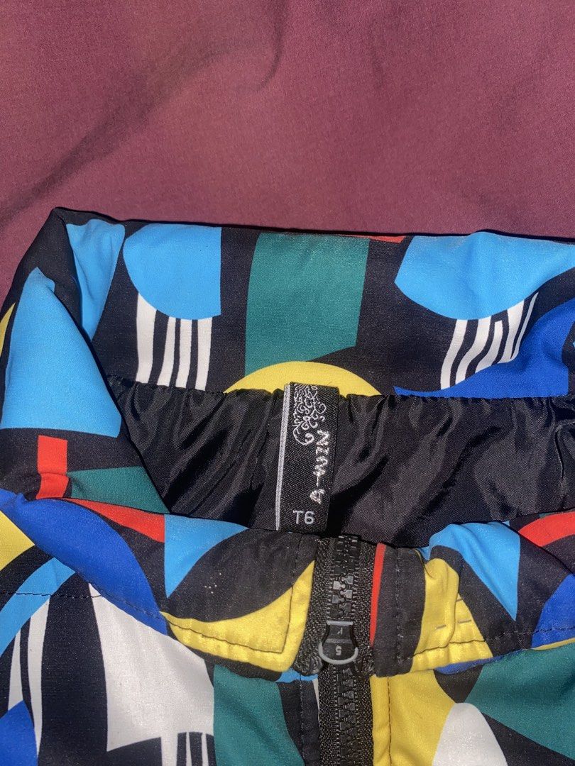 A-WIN Abstract Print Vest (Category: Vests) located in Manila. Submitted by jessymessy_dadealer (Listing ID 1427568544, Image 3). Description: Stylish vest featuring a vibrant abstract print. It has a full-length zipper and a stand-up collar. The vest is sleeveless with black trim along the armholes and hem. The size is T6. The vest is padded for warmth and comfort. It has a unique and eye-catching design..