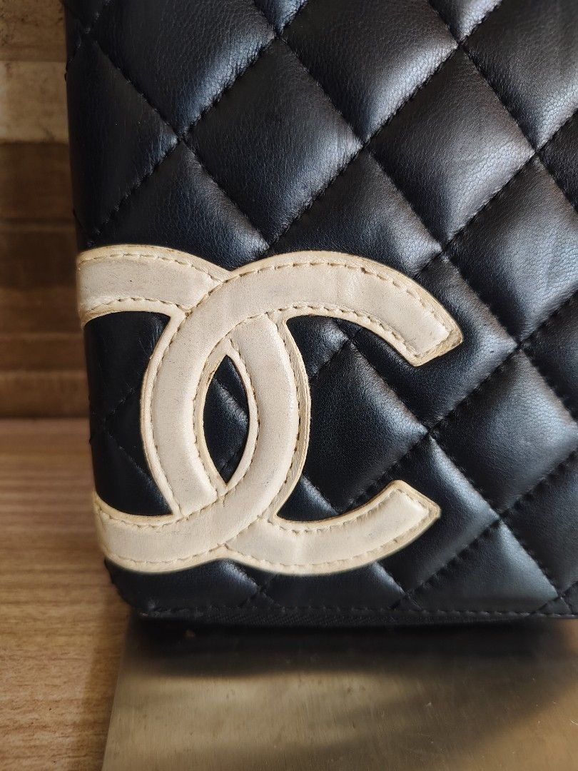Chanel Quilted Wallet (Category: Luxury Bags & Wallets) located in Manila. Submitted by 3ds_jpn (Listing ID 1427637967, Image 2). Description: Black quilted wallet with a white Chanel logo on the front. Features a zip-around closure and a chain detail. The interior is pink with multiple card slots and embossed Chanel logos. Includes a small chain with a Chanel tag. The wallet has a diamond pattern on the back..