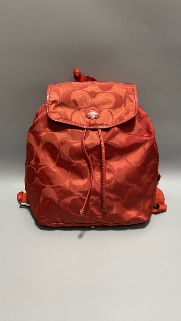 Coach Signature Backpack (Category: Luxury Bags & Wallets) located in Manila. Submitted by owabaet12 (Listing ID 1427633508, Image 1). Description: Coach backpack features a signature pattern in a vibrant orange color. It has a drawstring closure and adjustable straps. The backpack includes a Coach logo emblem. The design includes a flap closure and a small leather tag..