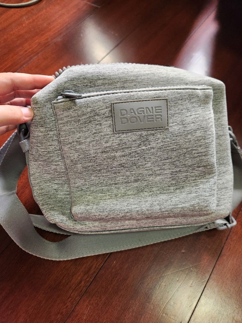 Dagne Dover Ace Crossbody Bag (Category: Cross-body Bags) located in Makati City. Submitted by mikamix (Listing ID 1427501390, Image 1). Description: Dagne Dover Ace crossbody bag features a gray exterior with a zippered main compartment and an adjustable strap. The bag has a front pocket and a mesh interior pocket. The interior is lined with a gray fabric..