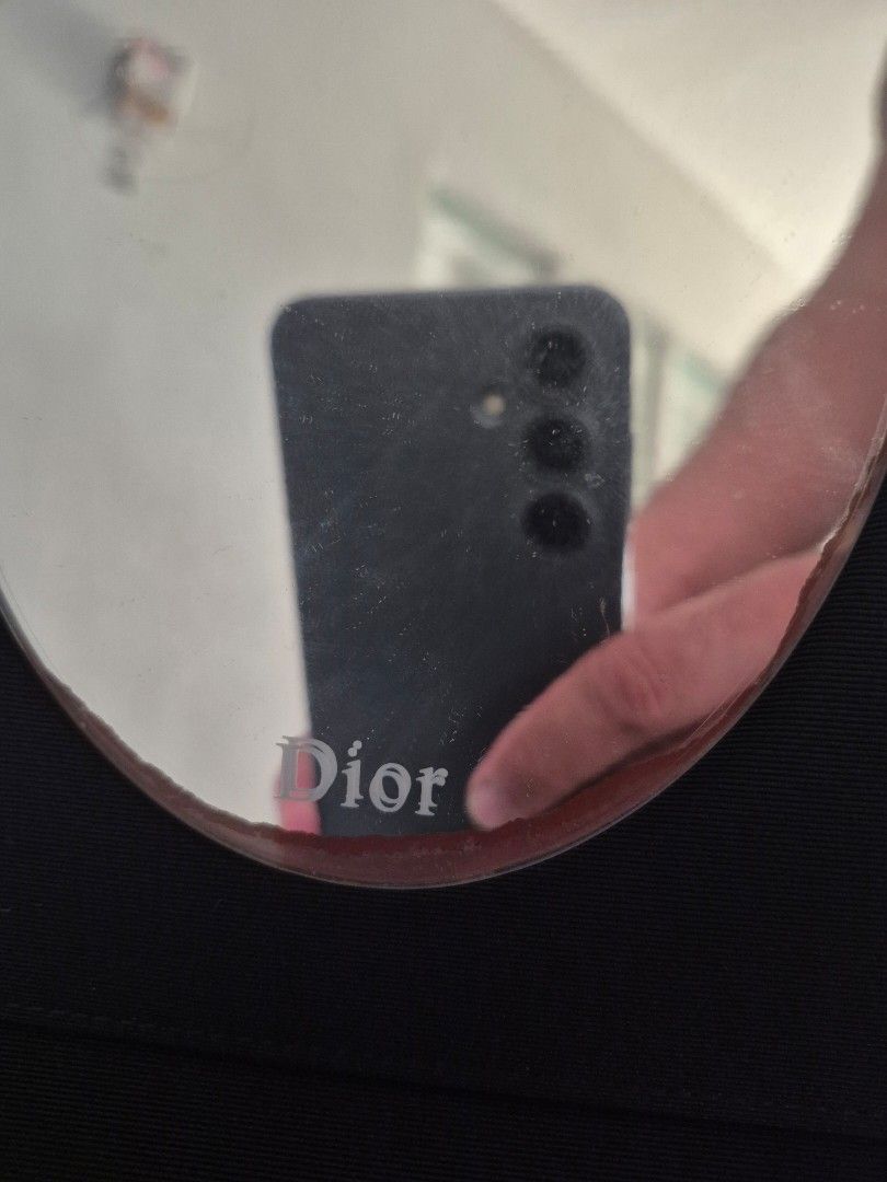 Dior Compact Mirror (Category: Mirrors) located in Santa Rosa. Submitted by thesecondshelf (Listing ID 1427569841, Image 3). Description: Dior compact mirror in a black case. The mirror has the Dior logo etched on it. The case is square-shaped and has a ribbon closure. The mirror is oval-shaped. Issue: mirror stain on the lower part. It still has its mirror protector. .