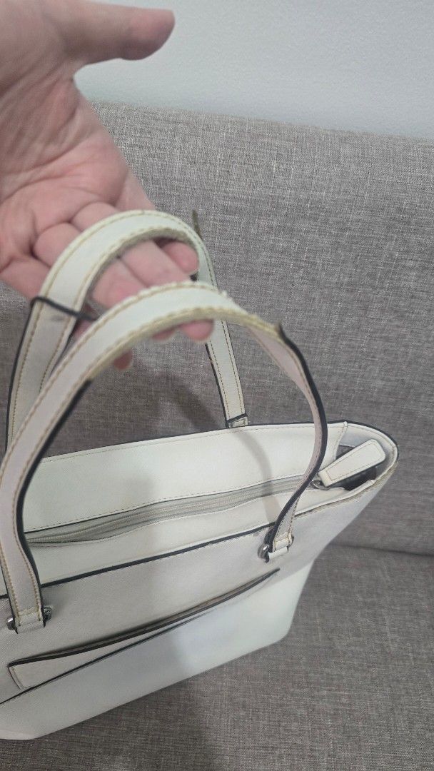 Guess White Tote Bag (Category: Tote Bags) located in Quezon City. Submitted by k8_wallace (Listing ID 1427498771, Image 3). Description: Nice and sturdy bag. It was gifted a couple of years ago. Spacious interior. Authentic Flaws: Leather trim on handle peeling off Dirt on surface. Stain from clothing at the back of the bag. All sales are final. GCash or BPI payments only.