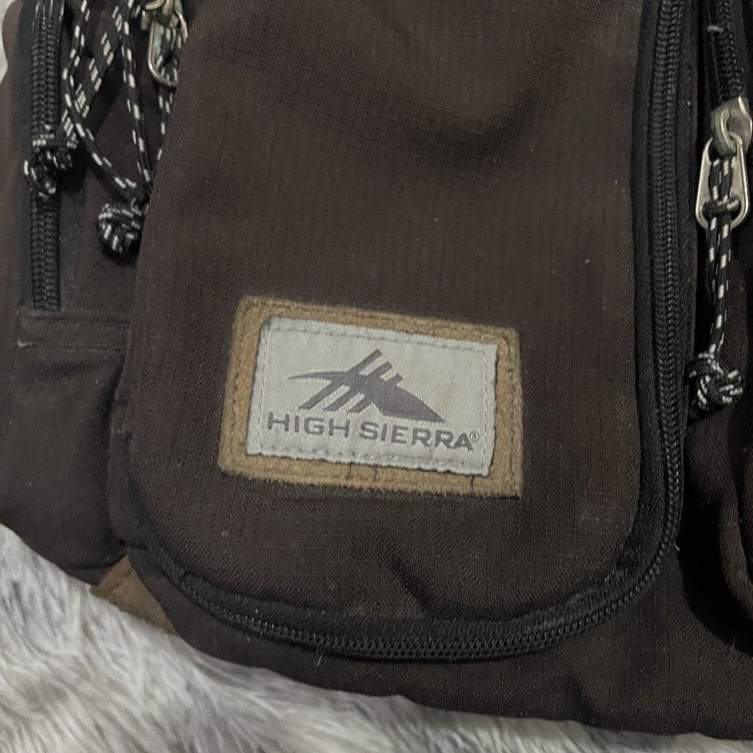High Sierra Backpack (Category: Backpacks) located in Trece Martires City. Submitted by zav_vinny (Listing ID 1427602717, Image 3). Description: Durable High Sierra backpack in brown. Features multiple compartments, including two front pockets with zipper closures. The main compartment has a zipper closure and a padded back panel. The High Sierra logo is visible on the front..