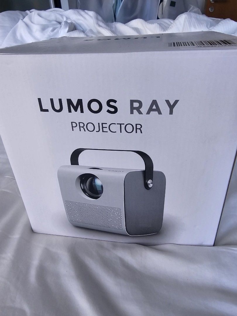 Lumos Ray Projector - Basic (Category: Projectors) located in Singapore. Submitted by jot161921 (Listing ID 1427488771, Image 3). Description: Lumos Ray projector. Features multiple input ports including HDMI, USB, and TF card. Compact and portable design. Perfect for home entertainment or presentations. The LUMOS RAY Smart Projector is superior for home entertainment, featuring a built-in Android OS with Wi-Fi, native Netflix/YouTube, Bluetooth,