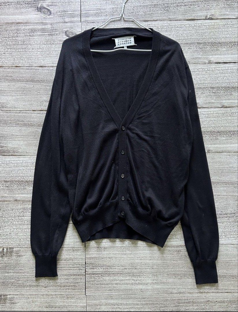 Maison Margiela Black Cardigan (Category: Coats, Jackets and Outerwear) located in Tarlac. Submitted by ae01019x (Listing ID 1427519154, Image 1). Description: Black cardigan from Maison Margiela. Features a V-neck and button closure. Made in Romania. Size L. Fabric composition: 60% Maglia Knit, 40% Wool. Includes care instructions. The item has the Maison Margiela label with the number 14..