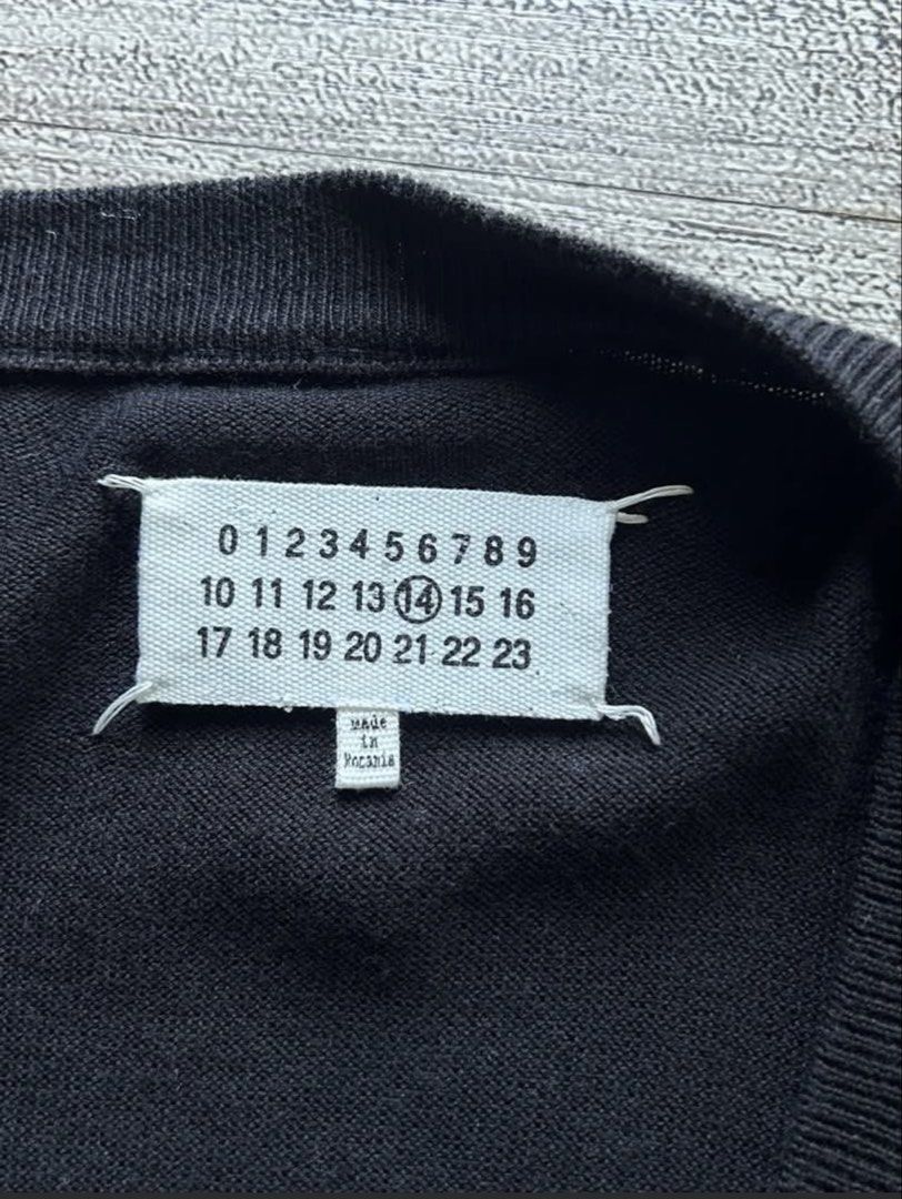 Maison Margiela Black Cardigan (Category: Coats, Jackets and Outerwear) located in Tarlac. Submitted by ae01019x (Listing ID 1427519154, Image 2). Description: Black cardigan from Maison Margiela. Features a V-neck and button closure. Made in Romania. Size L. Fabric composition: 60% Maglia Knit, 40% Wool. Includes care instructions. The item has the Maison Margiela label with the number 14..