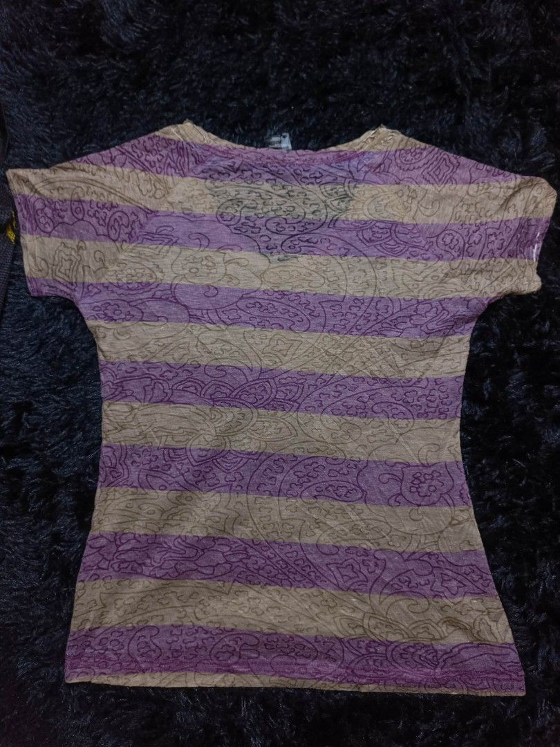 Ousco Graphic Print T-shirt (Category: Tshirts & Polo Shirts ) located in Manila. Submitted by brylelee7 (Listing ID 1427501730, Image 2). Description: Ousco t-shirt features a unique graphic print on the front. The back has a striped pattern. The shirt has a V-neck design. The size tag indicates it is a size 1. The shirt is made of polyester..