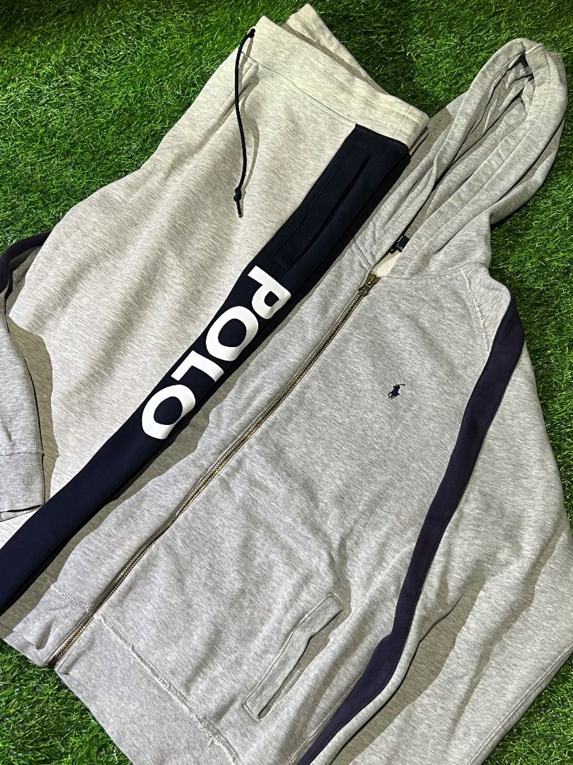 Polo Ralph Lauren Tracksuit Set (Category: Sets & Coordinates) located in Manila. Submitted by dbygotpaid (Listing ID 1427593008, Image 2). Description: Polo Ralph Lauren tracksuit set includes a hooded jacket and matching pants. The jacket features a full zip closure and the iconic Polo logo. The pants have a drawstring waist and a contrasting stripe detail with the Polo logo. Both pieces are in a light grey color with navy blue accents. The siz