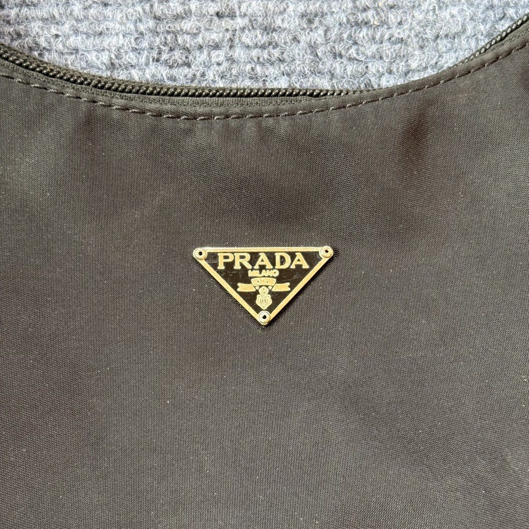 Prada Nylon Hobo Bag (Category: Luxury Bags & Wallets) located in Kabacan. Submitted by rags2penny.phl (Listing ID 1427608446, Image 3). Description: Prada nylon hobo bag. Features a top handle and a zip closure. The interior lining has a Prada Milano label. The exterior has a Prada triangle logo. The zipper pull shows some wear. A great everyday bag. issue : peel off on puller zip (see last photo).