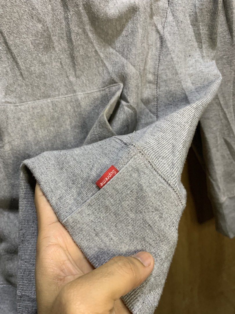Supreme Box Logo Hoodie (Category: Hoodies) located in Manila. Submitted by thriftstwodrips (Listing ID 1427513037, Image 3). Description: Supreme Box Logo hoodie in grey. Features a yellow box logo on the chest and a small Supreme tag on the sleeve. Made of 100% cotton. Includes a hood with drawstrings and a kangaroo pocket. Made in Canada..