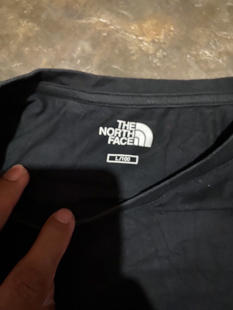 The North Face Black T-shirt (Category: Tshirts & Polo Shirts ) located in Cavite. Submitted by jamstore89 (Listing ID 1427622959, Image 3). Description: The north face shirt large 21.5x27" P400 Black The North Face t-shirt. Features the brand logo on the front. The size is L/100. The tag shows the material composition and care instructions. A classic and versatile piece for everyday wear..