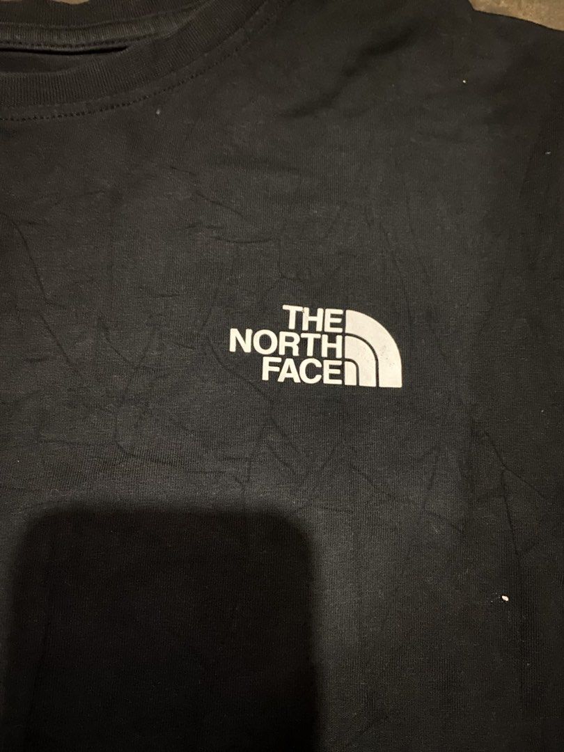 The North Face Black T-shirt (Category: Tshirts & Polo Shirts ) located in Cavite. Submitted by jamstore89 (Listing ID 1427622959, Image 2). Description: The north face shirt large 21.5x27" P400 Black The North Face t-shirt. Features the brand logo on the front. The size is L/100. The tag shows the material composition and care instructions. A classic and versatile piece for everyday wear..