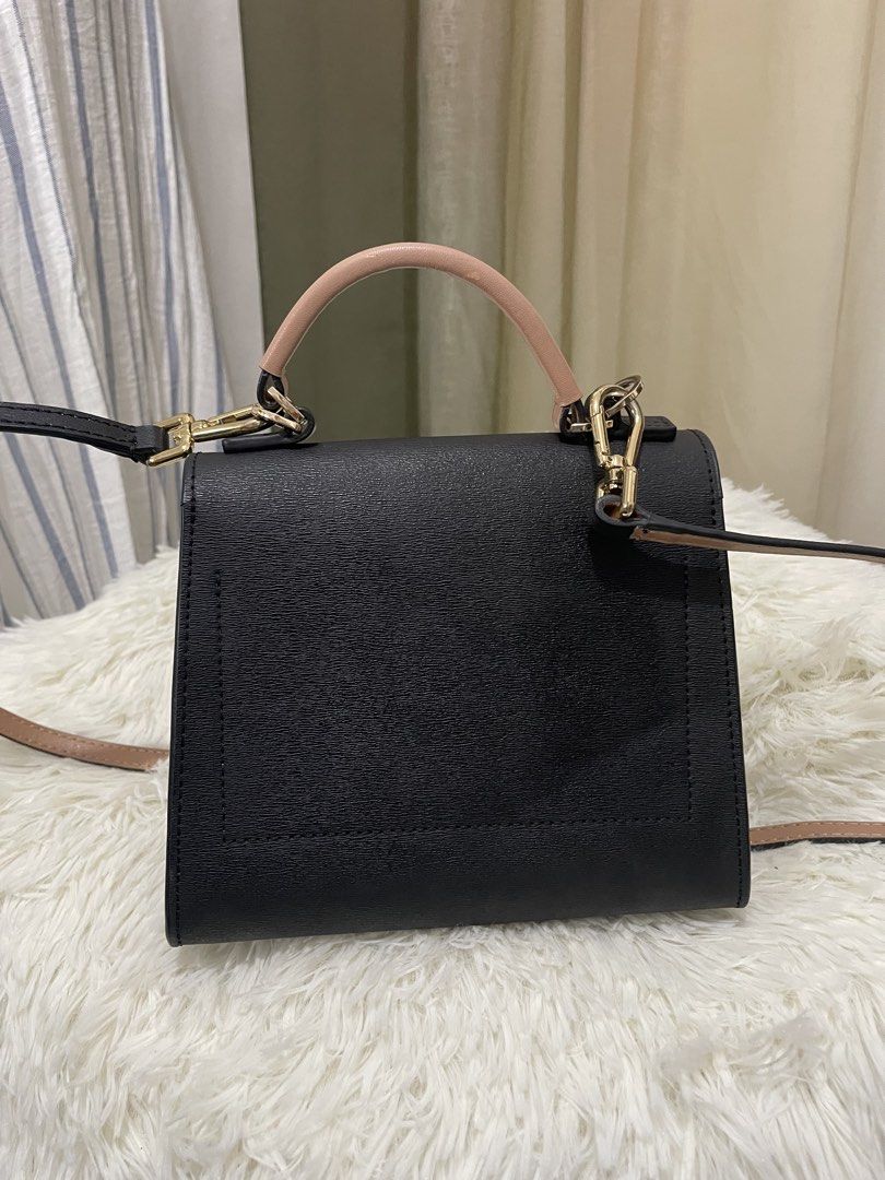 Tory Burch Black Satchel Bag (Category: Luxury Bags & Wallets) located in Cabanatuan. Submitted by moraiahraven (Listing ID 1427509796, Image 2). Description: Tory Burch satchel bag features a black exterior with a top handle and a detachable shoulder strap. The interior is a light beige color. The bag has a flap closure with a gold-tone logo detail. The bag can be worn as a shoulder bag or carried by the top handle..