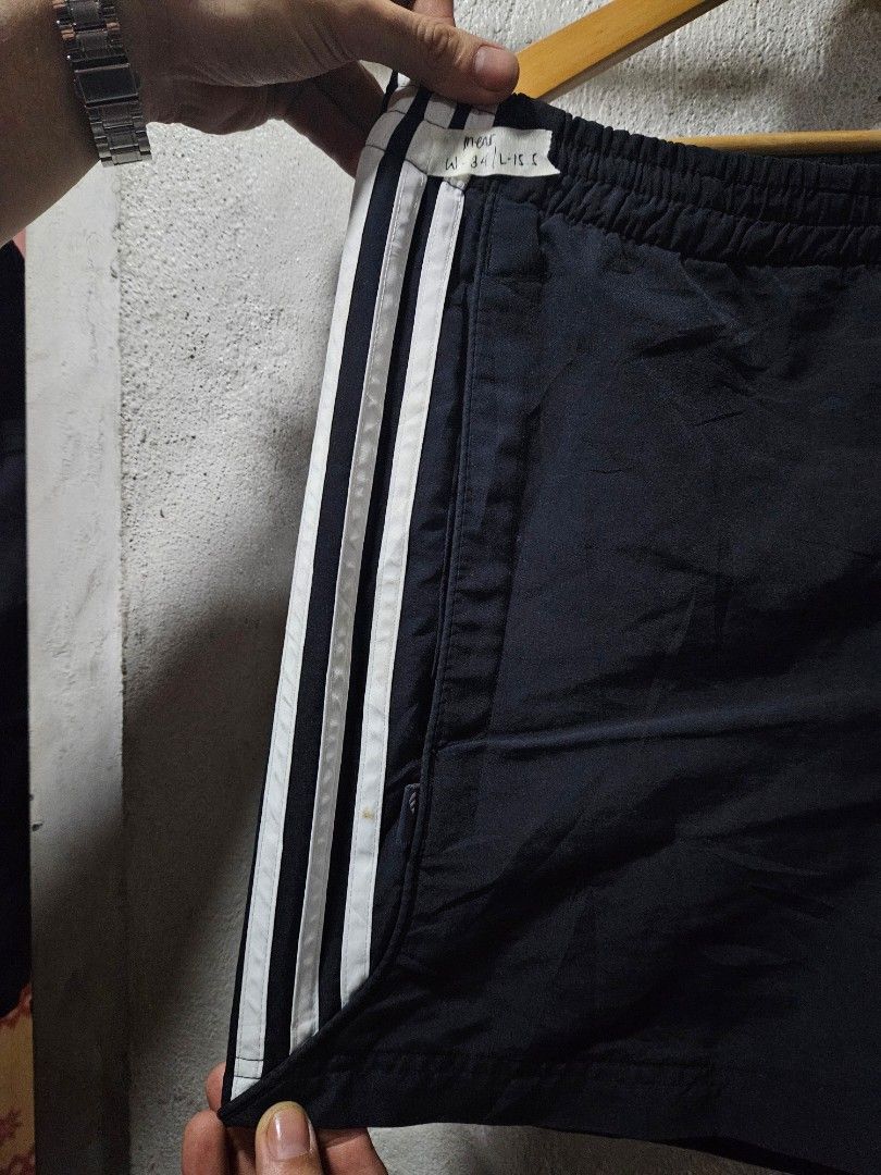 Adidas Black Shorts with White Stripes (Category: Shorts) located in Quezon City. Submitted by itsmeriaa (Listing ID 1427732697, Image 2). Description: Adidas black shorts with white stripes. Features the Adidas logo and size tag. The shorts have an elastic waistband. The shorts have the classic Adidas three-stripe design on the side. DIMES ✔️ W : 32 L : 30.5 Color rate : 9/10 No issue, in excellent cond. ✨️.